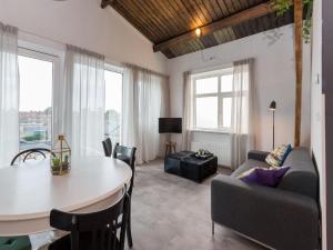 a living room with a table and a couch at Lovely modern 4 person apartment in the heart of Koudekerke in Koudekerke