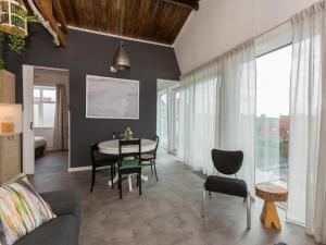 a living room with a table and a dining room at Lovely modern 4 person apartment in the heart of Koudekerke in Koudekerke