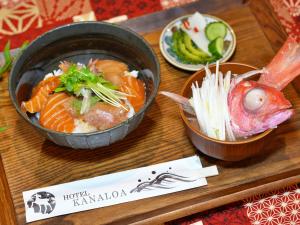 a wooden tray with two bowls of food and chopsticks at HOTEL KANALOA in Tokashiki