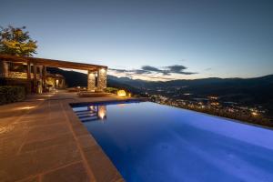 a swimming pool with a view of a city at night at Chalet Azanias in Kalavrita