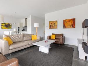 een woonkamer met een bank en een salontafel bij Brand new luxury villa on a small scale park with its own jetty in Zeewolde