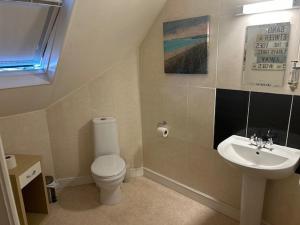 a bathroom with a toilet and a sink at Chequers Country Inn in Lutterworth