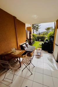 un patio con mesa, sillas y sofá en CAP ESTEREL Appartement, en Agay - Saint Raphael