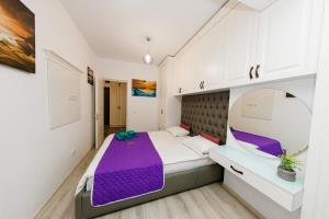 1 dormitorio con cama morada y espejo en 17 Zimbrului Residence at Lazar Towers Palas, en Iaşi