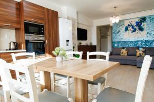 Una cocina y una sala de estar con una mesa y sillas de madera. en 17 Zimbrului Residence at Lazar Towers Palas, en Iaşi