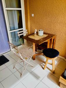 a wooden table and a chair and a table and a cup at CAP ESTEREL Appartement in Agay - Saint Raphael