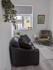 um sofá de couro preto numa sala de estar com uma janela em The boot factory em Leicester