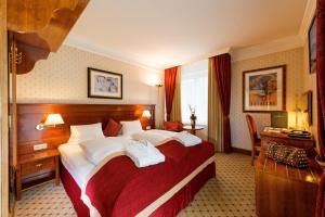 a hotel room with a large bed and a desk at Hotel Salzburger Hof in Bad Gastein