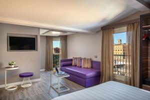 um quarto de hotel com um sofá roxo e uma janela em The Republic em Roma