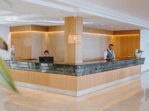 lobby z dwoma mężczyznami siedzącymi przy recepcji w obiekcie Grupotel Aguait Resort & Spa - Adults Only w Cala Ratjada +37 zdjęć