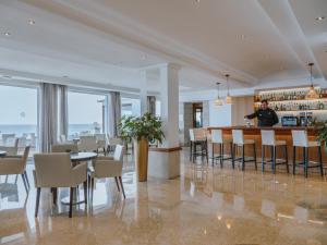 mężczyzna stojący w barze w restauracji w obiekcie Grupotel Aguait Resort & Spa - Adults Only w Cala Ratjada