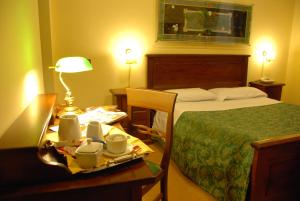 una habitación de hotel con una cama y una mesa con una bandeja de platos en Hotel del Centro en Palermo