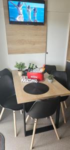 une table en bois avec des chaises et une télévision murale dans l'établissement Mobile house Tina 31, à Metlika