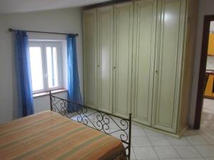 a bedroom with a bed and a large cabinet at Appartamento Leopardi in Castiglione della Pescaia