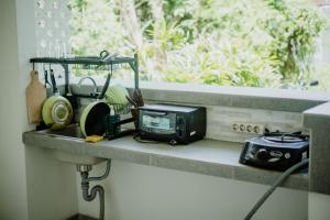 a kitchen counter with a toaster and a microwave at Kayuma Catu Canggu in Canggu