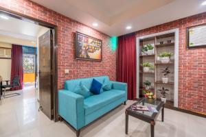 uma sala de estar com um sofá azul e uma parede de tijolos em Lime Tree 4 BHK Serviced Apartment Greater Kailash -2 em Nova Deli