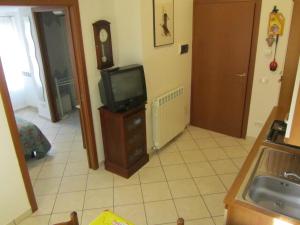 a kitchen with a tv on a dresser in a room at Appartamento Leopardi in Castiglione della Pescaia