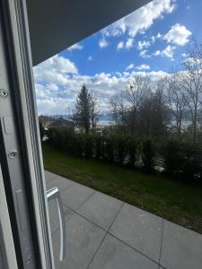 vistas desde una puerta corredera de cristal de un patio en Luxurious Studio with Lake View near Zurich, en Uetikon am See