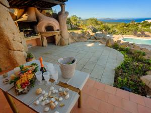 un tavolo con un piatto di cibo e una bottiglia di vino di Sardinia Family Villas - Villa Letizia with private pool and seaview a Cannigione