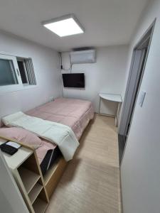 Kleines Zimmer mit einem Bett und einem Schreibtisch. in der Unterkunft Ribini house in Seoul