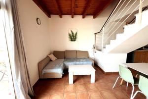 a room with a couch and a table and stairs at CASA ALICIA - by 'Fuga A Fuerte' in Cotillo