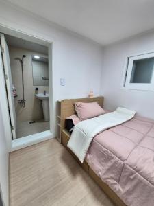 a bedroom with a large bed and a bathroom at Ribini house in Seoul