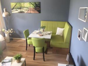 een eetkamer met een tafel en groene stoelen bij Modern Apartment in Noordwijk near the Sea in Noordwijk