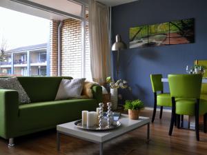 een woonkamer met een groene bank en een tafel bij Modern Apartment in Noordwijk near the Sea in Noordwijk