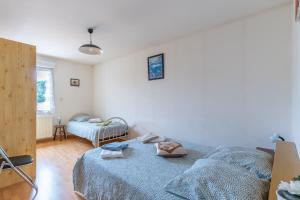 a bedroom with a bed with a blue comforter at Gîte Lauréac - Maison avec jardin in Pessac