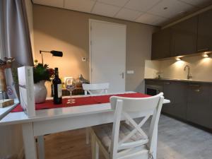 een keuken met een tafel met een fles wijn en een glas bij Alluring Apartment in Bergen with Terrace Garden and BBQ in Bergen