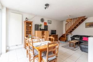 a dining room with a table and a living room at Gîte Lauréac - Maison avec jardin in Pessac