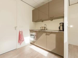 een keuken met witte muren en roestvrijstalen apparatuur bij Alluring Apartment in Bergen with Terrace Garden and BBQ in Bergen