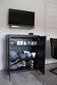 a black cabinet with plates and dishes in it at Boxtel, Appartement (1-4p) nabij station/centrum in Boxtel