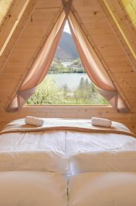 a bed in a room with a large window at Cottages Relax in Jajce