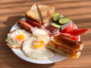 a plate of breakfast food with eggs sausage and toast at Noes House in K'obulet'i