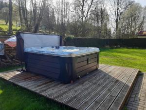 a hot tub sitting on a deck in a yard at Ubytování BRLOH Sedloňov v Orlických horách in Sedloňov