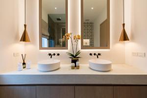 2 lavabos en un baño con 2 espejos en Infinity Seaview Villa, en Mae Nam