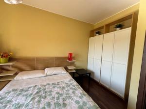 ミラノにあるDolceFuturismoのベッドルーム1室(ベッド1台付)、壁に白いキャビネットが備わります。