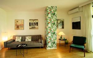 sala de estar con sofá y silla en Luxury 1BR Apartment In The Center of Tbilisi, en Tiflis