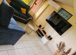 an overhead view of a living room with a couch and a tv at Paradis Spiritain in Saint Esprit