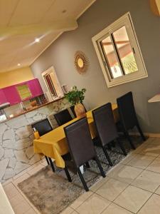 a dining room with a wooden table and black chairs at Paradis Spiritain in Saint Esprit