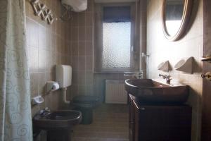 a bathroom with two sinks and a toilet and a window at Appartamenti SA in Follonica