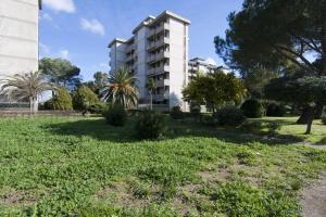 a building in a park with trees and grass at Appartamenti SA in Follonica
