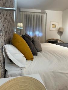 een slaapkamer met een groot wit bed met gele kussens bij Apartamento El Estanque - HA Peña Santa in Benia