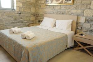 - une chambre avec un grand lit et des serviettes dans l'établissement Villa Thalassa - holidays at the beach of Kalamaki, à Kalamaki