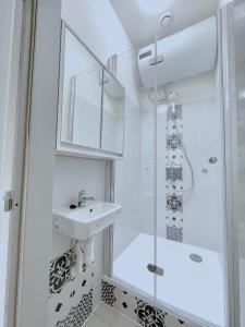 ein weißes Bad mit einem Waschbecken und einer Dusche in der Unterkunft New town Prague 5’ walk to Wenceslas Square in Prag