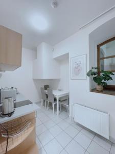 eine weiße Küche mit einem Tisch und einem Esszimmer in der Unterkunft New town Prague 5’ walk to Wenceslas Square in Prag