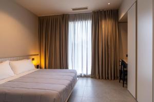 a hotel room with a bed and a window at Amare Suite & Apartments in Bellaria-Igea Marina