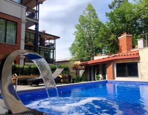 a pool with a fountain in front of a house at Seventeen Rooms in Tʼelavi