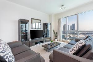 een woonkamer met een bank en een tv bij Incredible Fountain Views 2.5 BR Burj Residences in Dubai